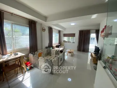 Spacious living room with play area and natural light, perfect for family gatherings.