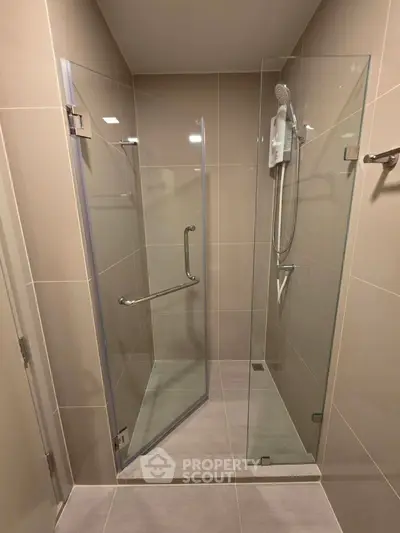 Modern bathroom with sleek glass shower enclosure and contemporary fixtures.