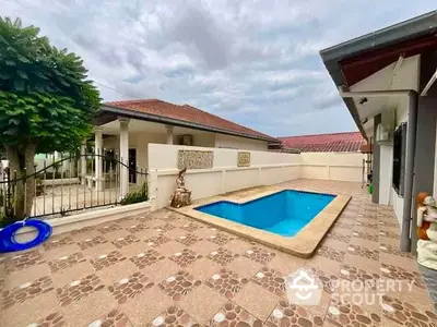 Charming backyard with private pool and tiled patio in a serene residential setting.