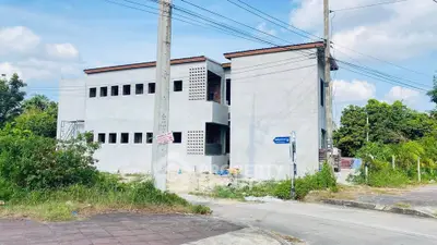 Modern unfinished building exterior with potential for development in a suburban area.