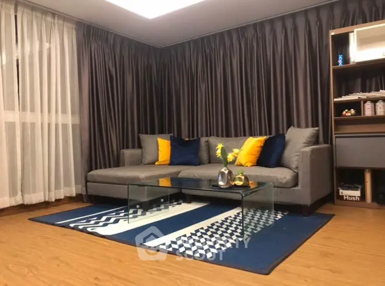 Stylish living room with modern gray sofa and vibrant decor accents.