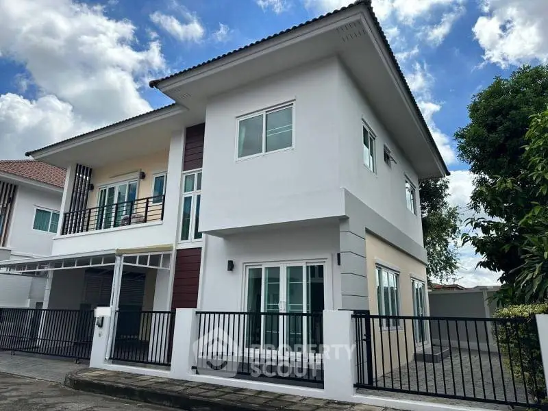Modern two-story house with sleek design and spacious outdoor area, perfect for family living.