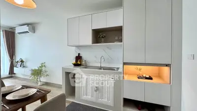 Modern kitchen with sleek cabinetry and dining area in a stylish apartment.