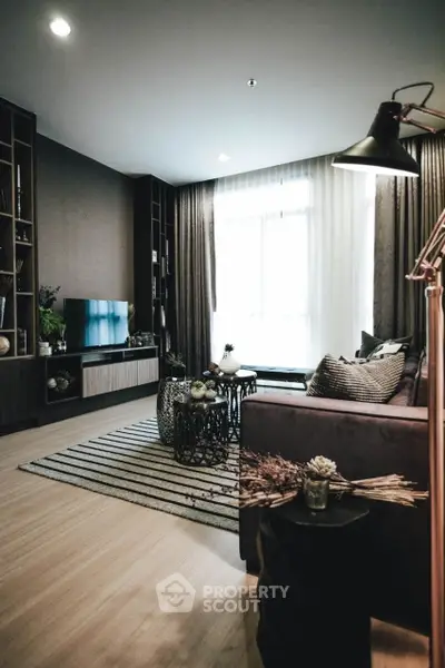 Stylish modern living room with cozy decor and large window for natural light.