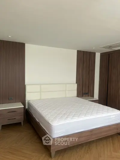 Spacious modern bedroom with elegant wooden furniture and cozy ambiance.