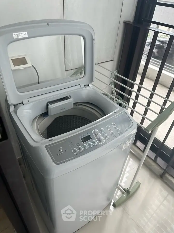 Modern washing machine in a sleek laundry area with natural light.