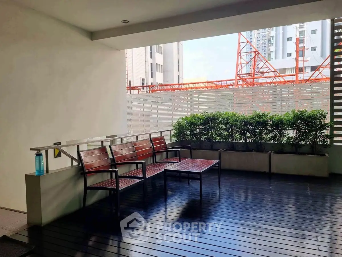 Modern building entrance with stylish seating and greenery, perfect for welcoming guests.