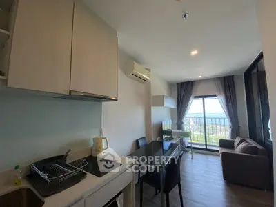 Modern apartment interior with kitchen and living room, featuring large windows and scenic view.