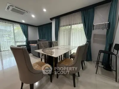 Elegant dining area with marble table and plush chairs in a modern living room setting.