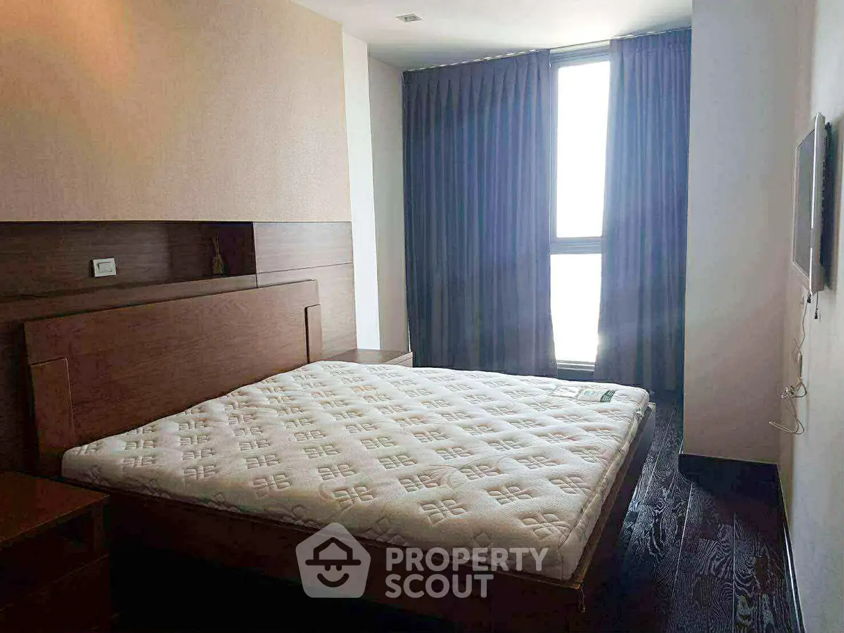 Spacious bedroom with large window and modern furnishings