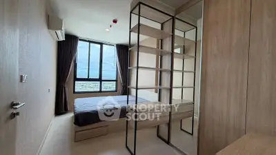 Modern bedroom with large window and stylish shelving unit, offering a bright and airy atmosphere.
