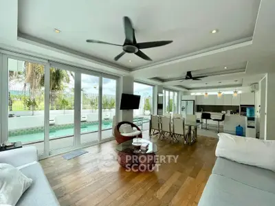 Luxurious open-plan living room with pool view and modern kitchen