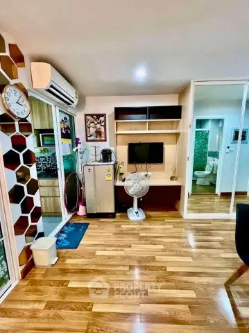 Modern living room with wooden flooring, air conditioning, and stylish decor in a cozy apartment.