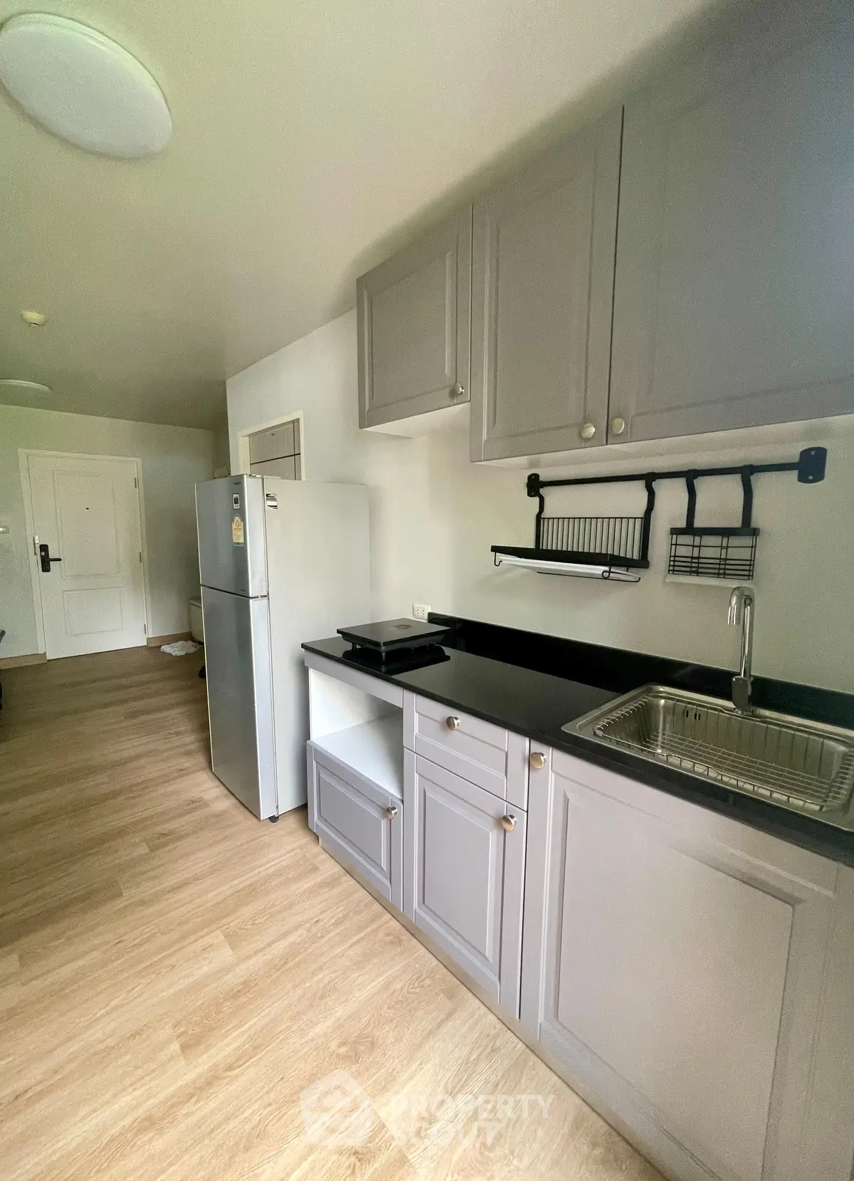 Modern kitchen with sleek cabinetry and stainless steel appliances in a cozy apartment.
