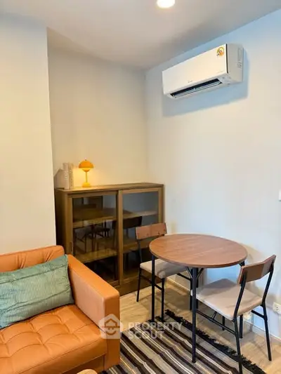 Cozy living room with modern furniture and air conditioning, perfect for relaxation.