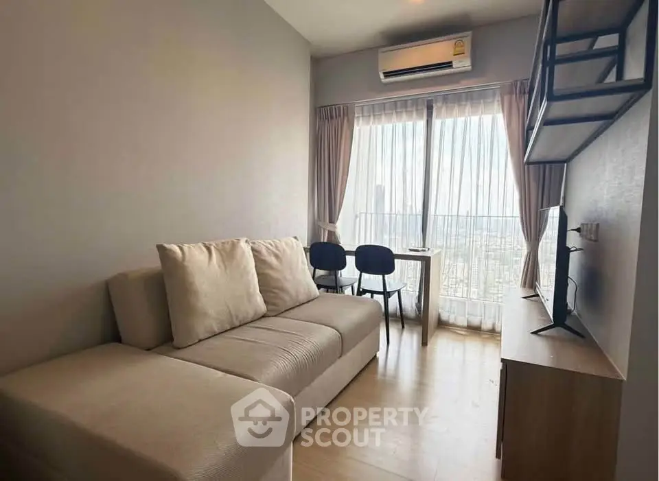 Modern living room with large window and city view, featuring cozy sofa and wall-mounted TV.