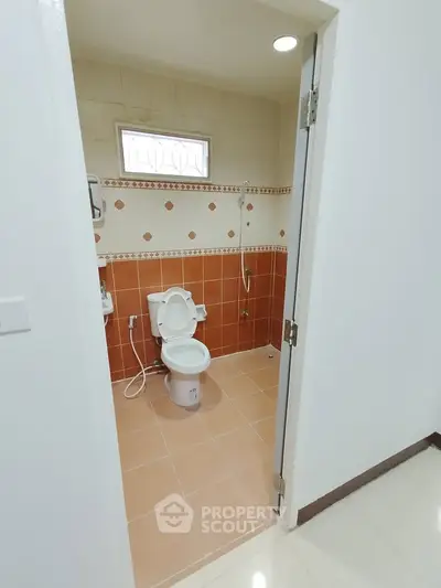 Modern bathroom with orange tile accents and white fixtures
