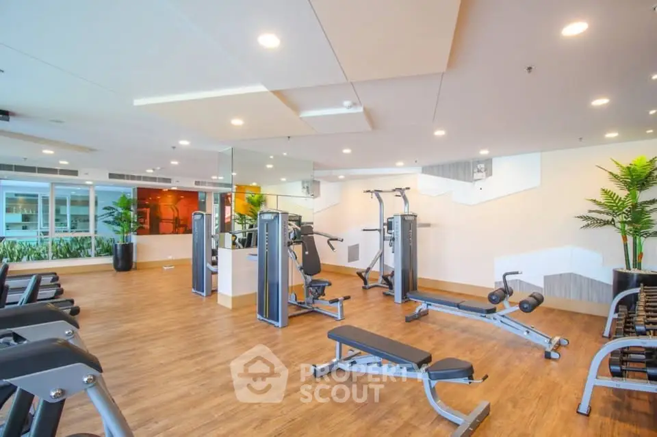 Spacious modern gym with state-of-the-art equipment and stylish decor.
