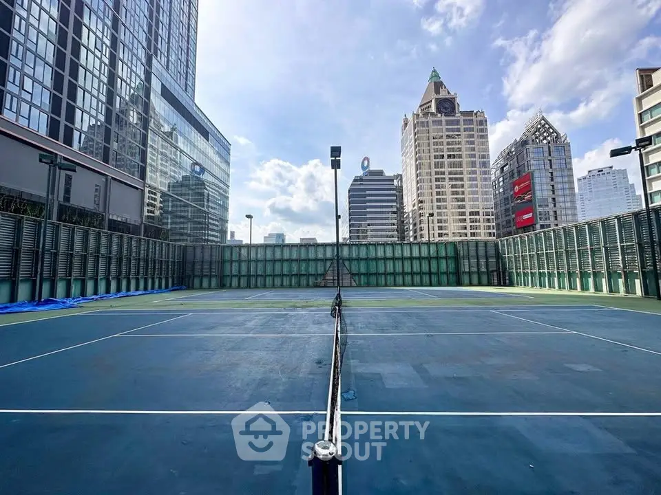 Stunning rooftop tennis court with city skyline views, perfect for urban living enthusiasts.