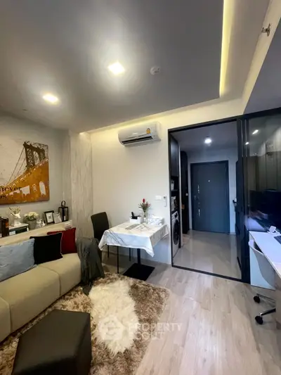 Modern living room with cozy decor and open kitchen layout in a stylish apartment.