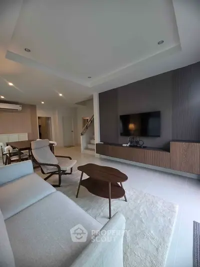 Modern living room with stylish furniture and open layout, featuring a sleek TV setup and cozy seating area.