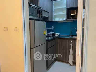 Modern compact kitchen with sleek cabinetry and stainless steel appliances