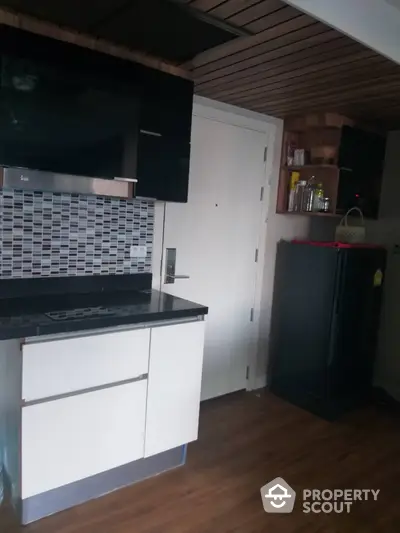 Modern kitchen with sleek cabinets and stylish backsplash in contemporary apartment.