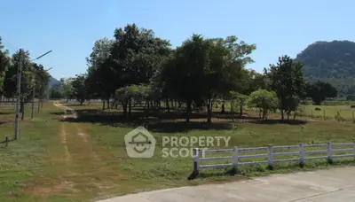 Scenic land plot with lush greenery and mountain backdrop, ideal for development.