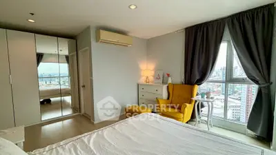 Bright bedroom with city view, featuring mirrored wardrobe and cozy yellow armchair.