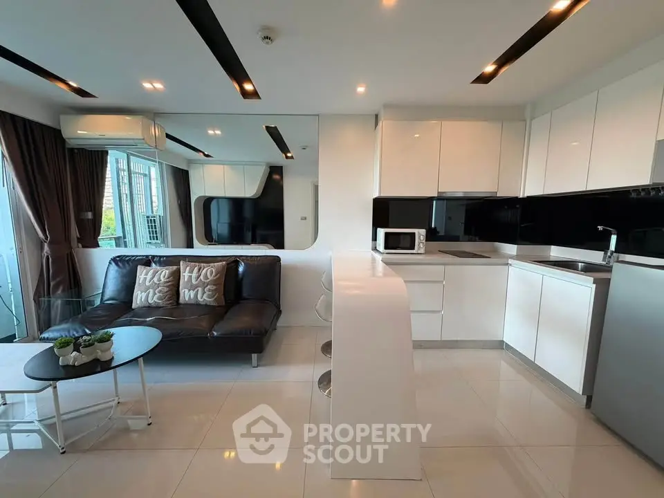 Modern open-layout kitchen and living room with sleek design and natural light.