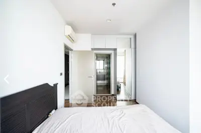 Modern bedroom with minimalist design and ensuite bathroom in a stylish apartment.