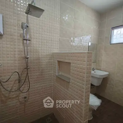 Modern bathroom with tiled walls and walk-in shower in a contemporary home.