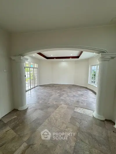 Spacious living room with elegant columns and large windows for natural light
