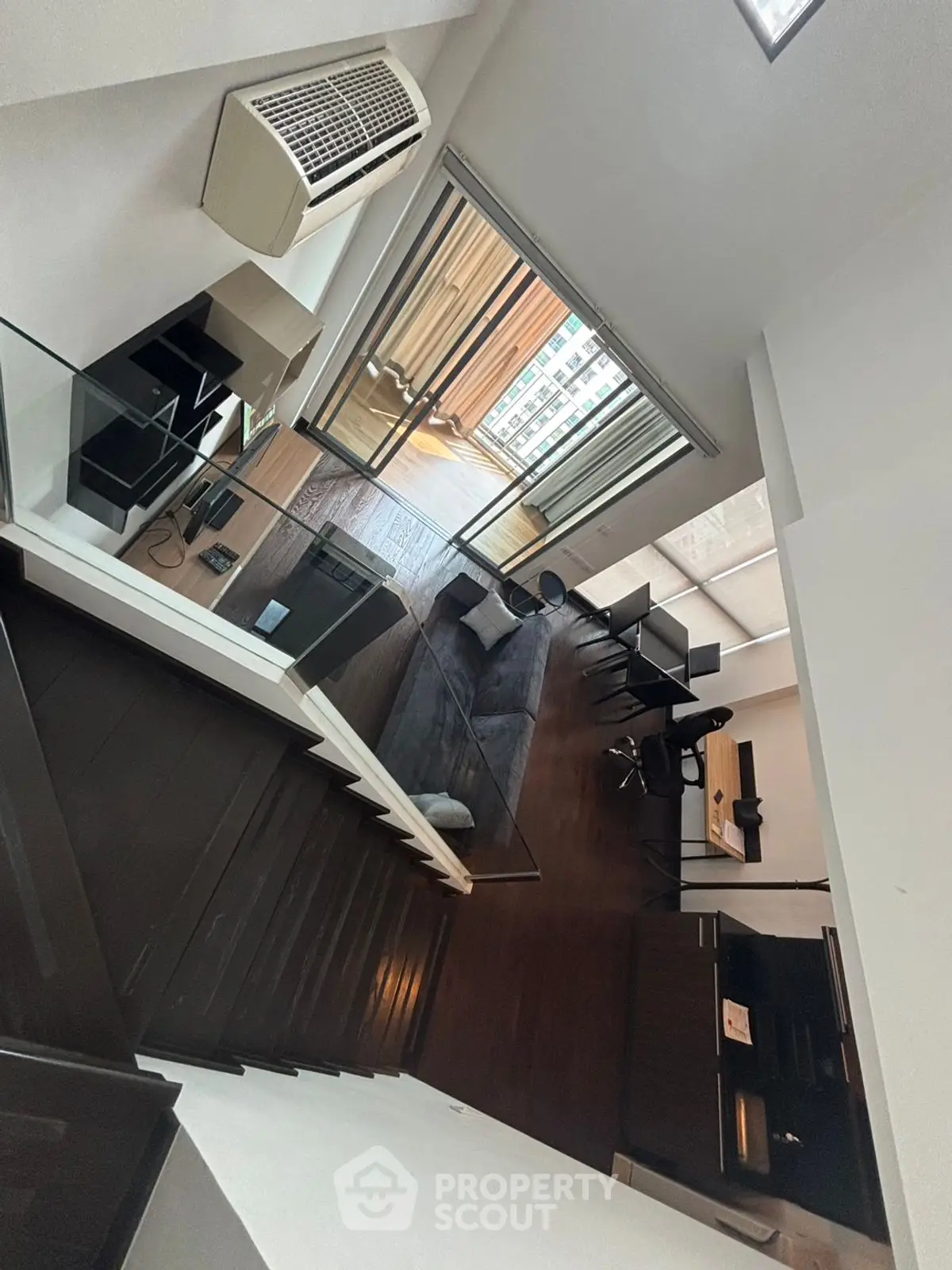 Modern loft apartment with open layout and large windows offering city views.