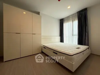 Spacious bedroom with modern wardrobe and large window for natural light