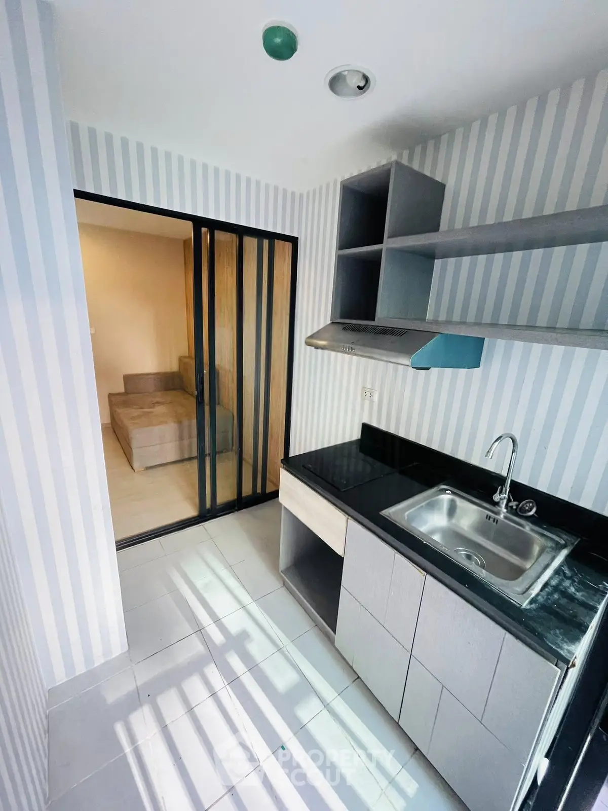 Modern kitchen with sleek cabinetry and sliding glass doors leading to a cozy living area.