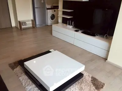 Modern living room with sleek furniture and in-unit washing machine.