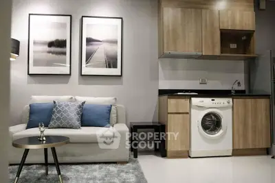 Modern living room with cozy sofa and stylish kitchen featuring a washing machine.