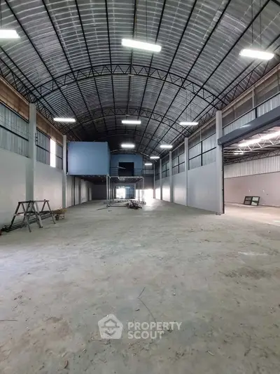 Spacious industrial warehouse with high ceilings and ample natural light.