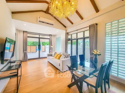 Spacious living room with elegant chandelier and large windows opening to a balcony.
