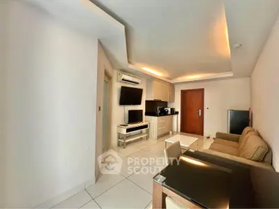 Modern living room with open kitchen, sleek furniture, and ambient lighting in a cozy apartment.