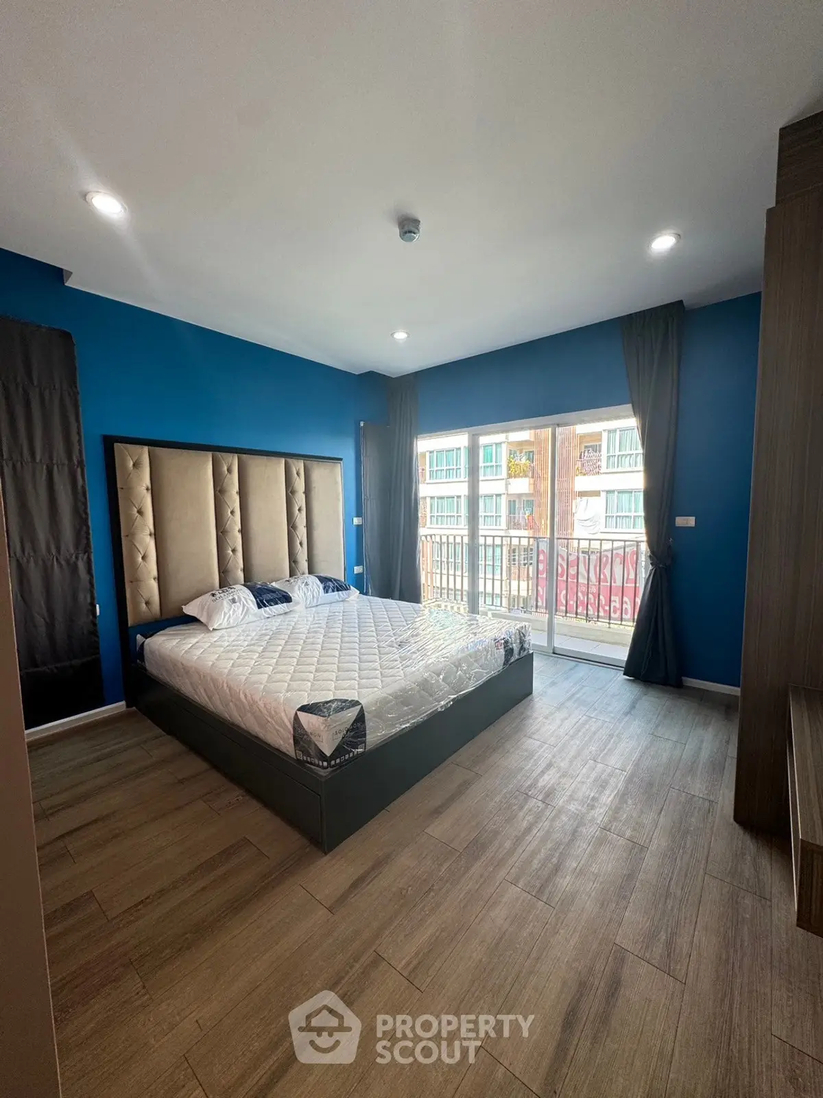 Spacious bedroom with modern decor and balcony access in a stylish apartment.