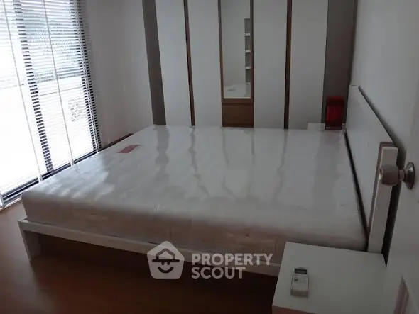 Spacious bedroom with large window and modern design, perfect for natural light lovers.