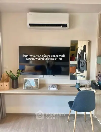 Modern study area with sleek desk, chair, and wall-mounted TV under air conditioning unit.