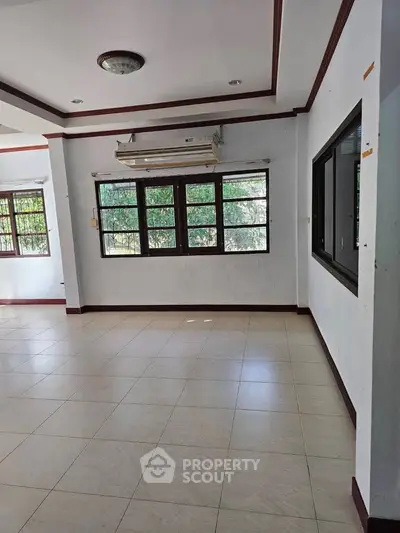 Spacious living room with large windows and air conditioning, perfect for natural light and comfort.