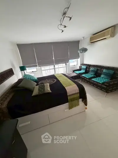 Spacious bedroom with modern decor and large windows for natural light.