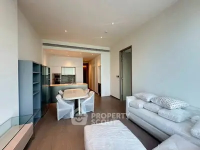 Modern living room with sleek furniture and open kitchen layout in a stylish apartment.