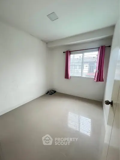 Spacious empty bedroom with tiled floor and window with pink curtains