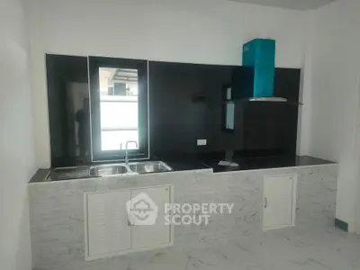 Modern kitchen with sleek black backsplash and marble countertops