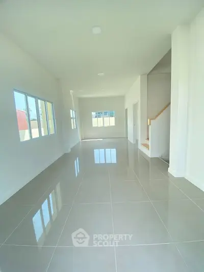 Spacious modern living room with large windows and glossy tiled floors
